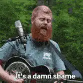 Man singing guitar it's a damn shame