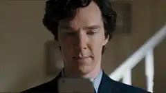 Sherlock smirks at his phone
