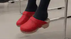 Red clogs tapping feet