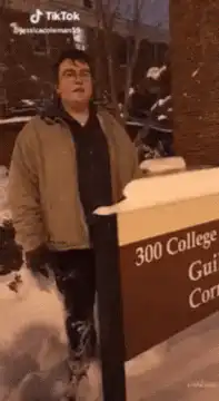 Man falls over college sign in snow