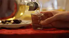 Pouring clear liquid into a shot glass