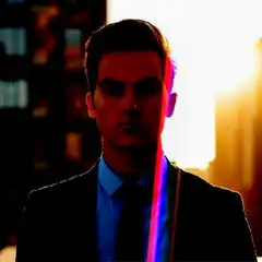 Man adjusting tie with rainbow lens flare