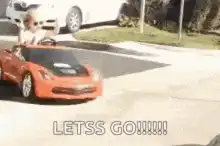 Toddler in toy car cheering