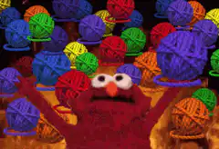 Elmo surrounded by yarn balls