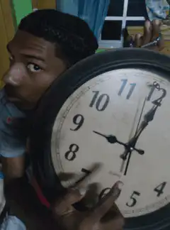 Man holding clock pointing at 7
