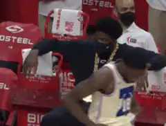 Joel Embiid sitting on bench with gold chain