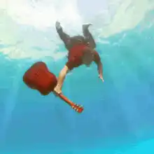 Man falling underwater with guitar