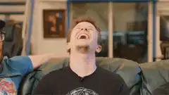 Man laughing hysterically on couch