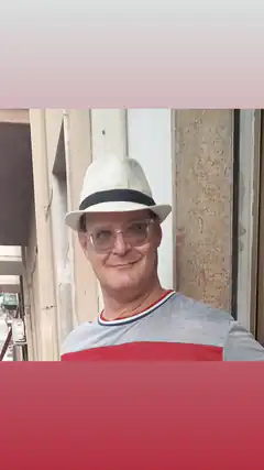 Man in fedora and glasses smiling