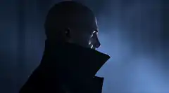 Bald man in dark coat profile