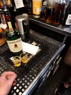 Two hands clinking Jameson whiskey shots