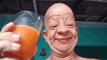 Bald man drinking orange juice