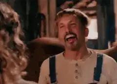 Man in overalls laughing hysterically
