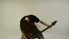 Long-haired bassist headbanging
