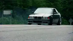 Black BMW drifting on a road