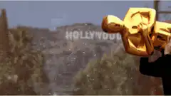 Person carrying giant Oscar statue