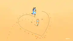 Bluey and Bingo drawing a heart in the sand