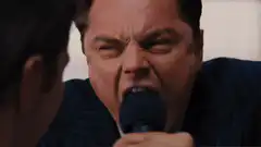 Jordan Belfort yelling into microphone