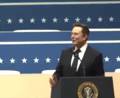 Elon Musk waving at podium