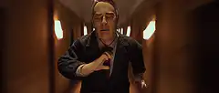 Edward Norton adjusting tie in hallway