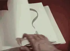 hand turning page with question mark