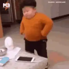 Chubby toddler dancing in orange sweater