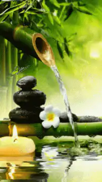 Zen bamboo water fountain with candles and stones