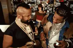 Two men with gold chains at a bar