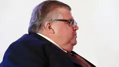 Man in suit and glasses looking sideways