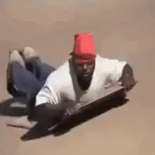 Man sliding on a board giving thumbs up