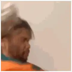man in orange jacket shaking head