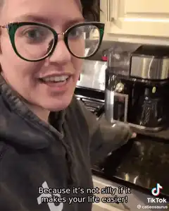 Woman with glasses talking about coffee maker