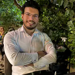 Man in white shirt smiling with arms crossed