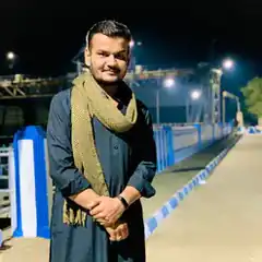 Man in traditional attire on a bridge at night