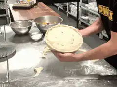 Chef holding up a raw pie
