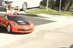 Toddler in toy car giving middle finger