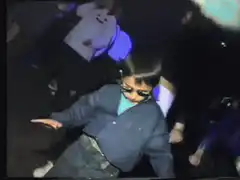 Kid in sunglasses dancing at club
