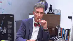 Bill Nye blows a party horn