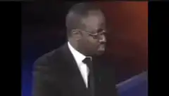 Man in suit looks down then up