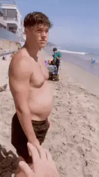 man flexes on beach