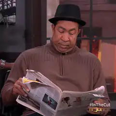 Man reading newspaper hides face