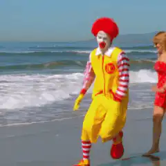 Ronald McDonald and woman on beach