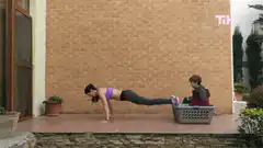 Woman doing pushups with kids in laundry basket