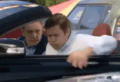Man vomiting over car
