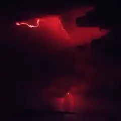 red lightning storm over water