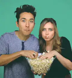 Couple eating popcorn with shocked faces