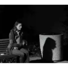 woman smoking on bench at night