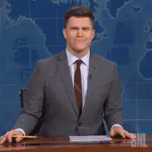 Colin Jost shrugs with a smile