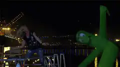 woman dancing with inflatable green tube man