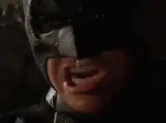 Batman grimacing in the rain